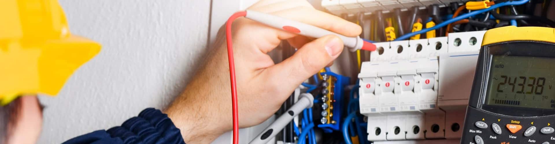 Cropped electrician installing electric cable wires of fuse switch box 1.jpg